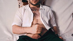 Handsome Noel Dero watches porn and caresses his dick in a condom close-up. Thumb
